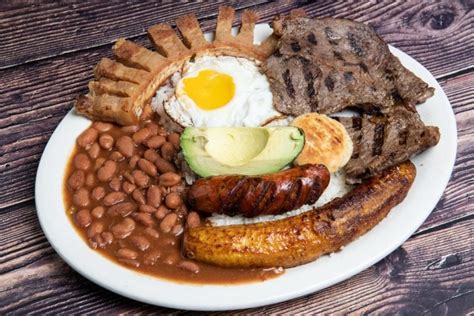  Bandeja Paisa: Ein kulinarisches Feuerwerk der südamerikanischen Aromen, das Ihren Gaumen auf eine unvergessliche Reise entführt!